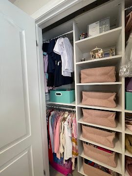 Linen closet organization with folded towels and labeled bins on tidy shelves